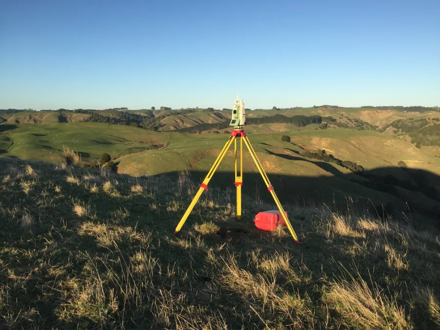 Total station on hillside while performing property surveying