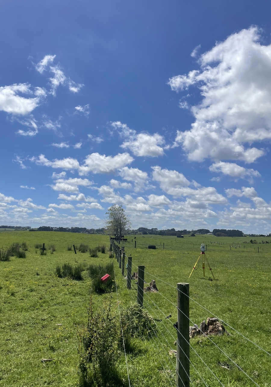 Surveying equipment set up across a rural property in Glenbrook Beach, Auckland.